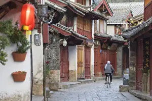 1 Person Prints: Woman cycling along alleyway, Lijiang (UNESCO World Heritage Site), Yunnan, China