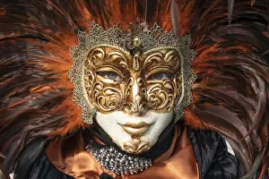 Images Dated 17th March 2020: A woman in a feather Venetian mask poses during the Venice Carnival, Burano, Venice