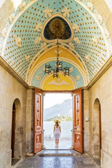 Dodecanese Islands Gallery: A woman in a hat at Panormitis Monastery, Symi, Dodecanese Islands, Greece