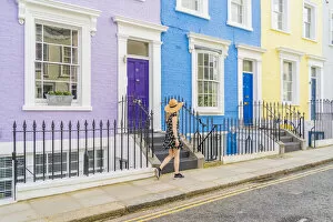 A woman in a hat walking in a pretty street in Notting Hill, London, England, Uk, (MR)