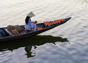 Candle Prints: Woman laying floating lanterns on the Perfume River at dusk, Hue, Central Vietnam