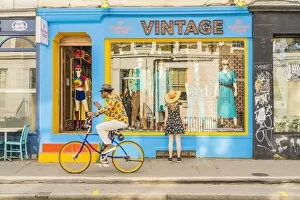 Bike Gallery: A woman looking in a vintage shop and a man riding his bike, Notting hill, London, England, Uk