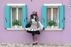 Costume Gallery: A woman poses in front of a colourful facade on Burano, Venice, Venato, Italy