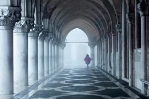 Arches Prints: Woman in red cape walking under the arches of the Doge's Palace