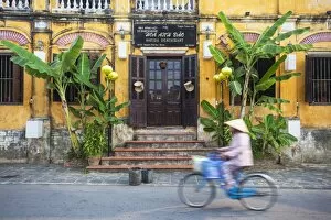 Images Dated 20th April 2014: Woman riding bicycle past restaurant, Hoi An (UNESCO World Heritage Site), Quang Ham
