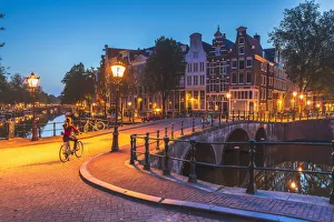 Bicylces Gallery: A woman riding a bike by night in Amsterdam along Keizersgracht canal in Amsterdam