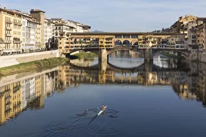 Oars Prints: A woman rows on the Arno river towards the Ponte Vecchio, Florence, Tuscany, Italy