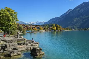 Woman sitting on the bank of Lake Brienz, Brienz, Berner Oberland, Switzerland