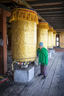 Shrine Collection: Woman spinning prayer wheels at the National Memorial Chhorten, Thimphu, Bhutan