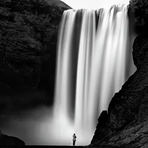 Skogar Prints: Woman standing and admiring Skogafoos waterfall, Skogar, South Iceland