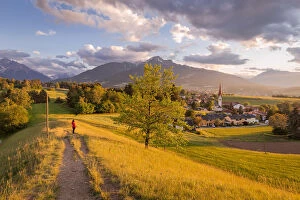 Images Dated 19th June 2020: A woman staring at the little village of Vill at sunset with the Saile mountain in the