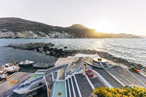 Woman at sunset at the colourful port of Mandraki on the island of Milos, Cyclades Woman at sunset at the colourful port of Mandraki on the island of Milos, Cyclades