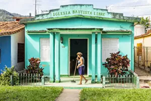 A woman sweeping the porch of her house in Vinales, Pinar del Rio Province, Cuba