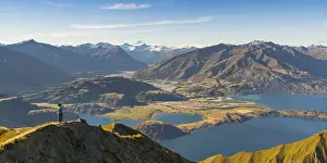 Woman taking photographs of Lake Wanaka and Mt Aspiring NP from Roys Peak track. Wanaka