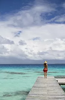 Woman walking on jetty, Fakarava, Tuamotu Islands, French Polynesia (MR)