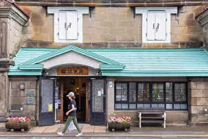 Hokkaido Prints: Woman walking past old stone store, Otaru, Hokkaido, Japan