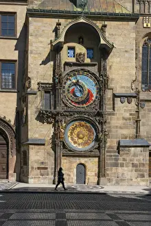 Old Town Hall Prints: Woman walking by Prague Astronomical Clock at Old Town Square, Prague, Bohemia