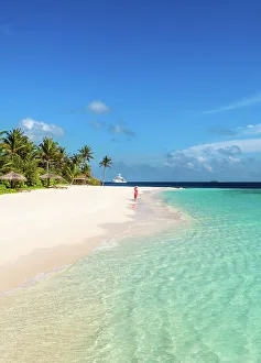 Woman walking on a sandy beach, Baa Atoll, Maldives