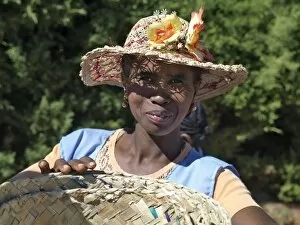 Images Dated 16th May 2007: A woman wearing a decorated Malagasy hat sells baskets in Ambalavao market
