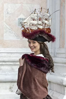 Images Dated 17th March 2020: A woman wearing a hat decorated with an old sailing ship poses at the Venice Carnival