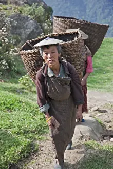 Bhutan Prints: Women with large bamboo baskets go to collect produce from their hillside farms in the Mangde Chhu Valley