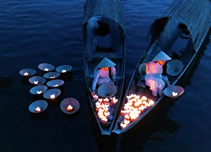 Candle Prints: Women laying floating lanterns on the Perfume River at dusk, Hue, Central Vietnam