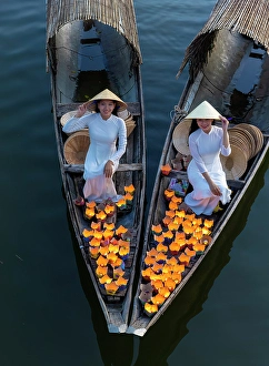 Candle Prints: Women laying floating lanterns on the Perfume River at dusk, Hue, Central Vietnam