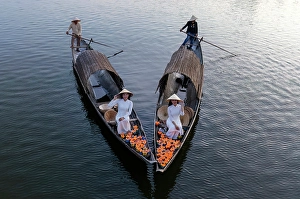 Candle Prints: Women laying floating lanterns on the Perfume River at dusk, Hue, Central Vietnam