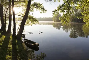 Sunlight Prints: Wooden fishing boats moored up on the dordogne river near Vayrac, Lot, Midi-Pyrenees