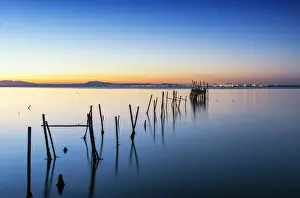 Wooden pillars pier, the palafite fishing harbour of Carrasqueira at dusk. Alcacer do Sal
