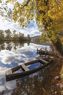 A wooden rowing boat in autumn on the Dordogne River, Correze, Nouvelle-Aquitaine