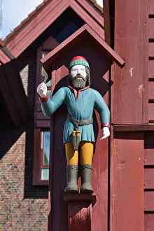 Wooden statue of St Jack on a wooden house facade. Warehouse in the Bryggen District