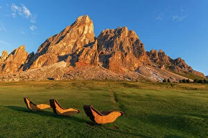 Silence Collection: Empty wooden sun loungers for hikers in the meadows of Sass De Putia rock, Passo delle Erbe
