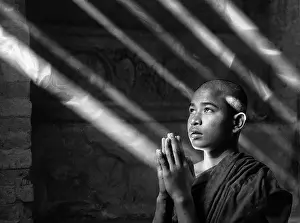 Praying Prints: Young Buddhist Monk praying in an ancient temple, Bagan, Myanmar