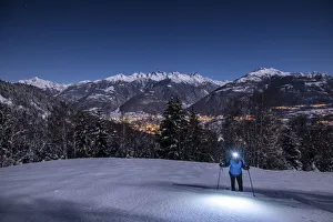 Girls Prints: Young girl with snowshoes in a night with full moon, Piazzola alp