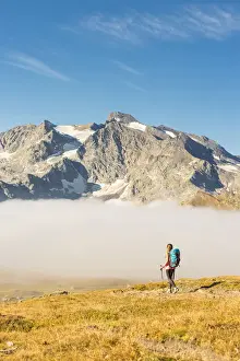 Orco Valley Prints: Young hiker walking along hill of Nivolet with Grand Aiguille Rousse in the background