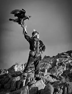 Eagle Prints: Young Kazakh Eagle Hunter posing with his Golden Eagle