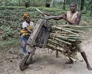 Worker Gallery: A young man and his wife push a homemade wooden bicycle