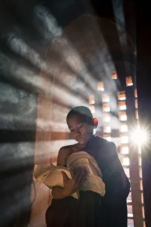 A young monk reading by a window inside a temple, UNESCO, Bagan, Mandalay Region, Myanmar