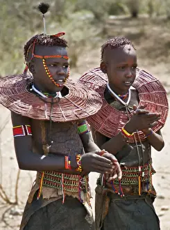 Two young Pokot girls wearing traditional ornaments that denote their unmarried status