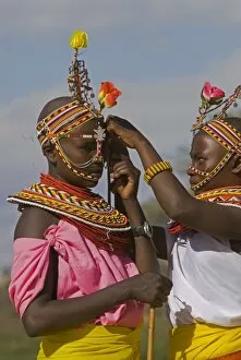 Adornment Gallery: Two young Samburu girls help each other preparing for a celebration
