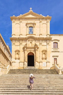 Young woman climbing the stairs of San Francesco all'Immacolata church, Noto