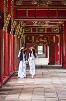 Images Dated 29th November 2018: Two young women wearing traditional national costume, ao dai, in the Imperial City